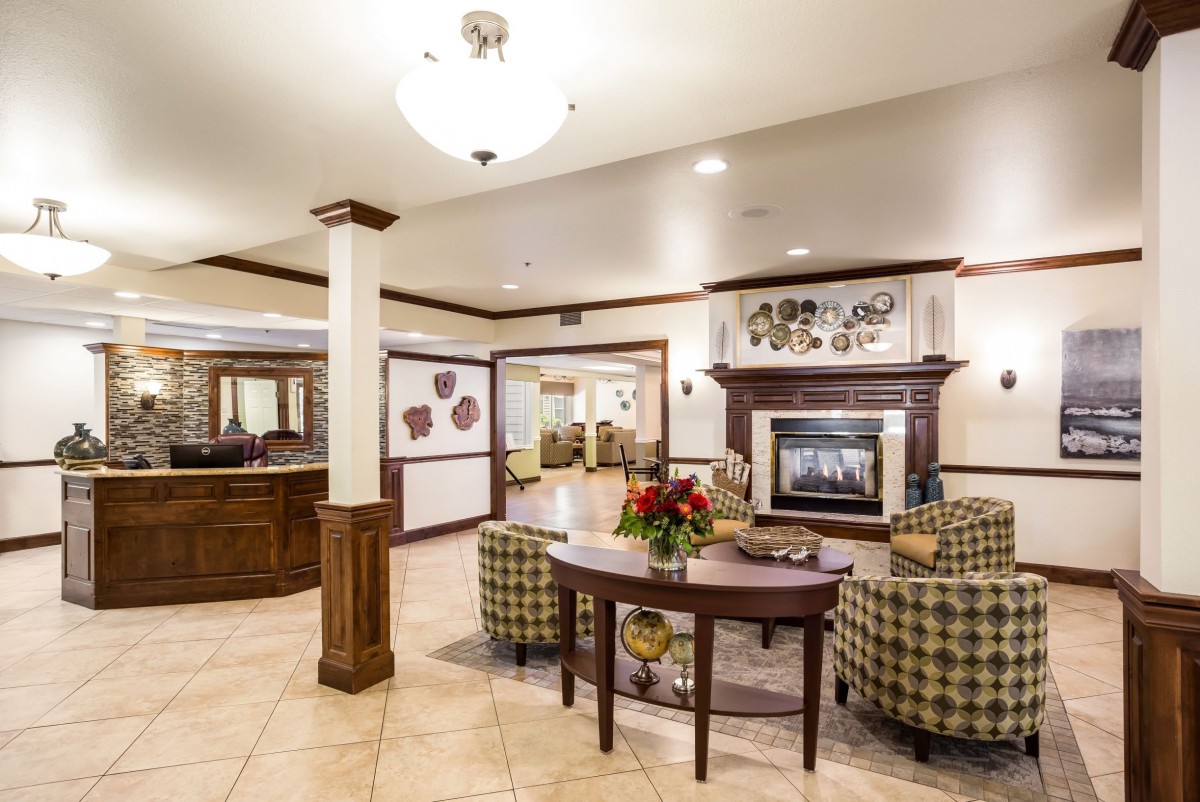 A cozy hotel lobby with comfortable seating and a warm fireplace.