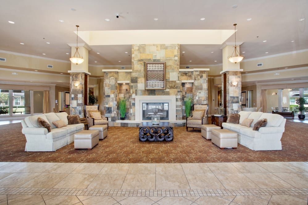 A luxurious and spacious lobby with elegant furniture and a central fireplace.