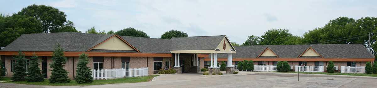 A single-story building with a prominent entrance, featuring columns and a gable roof.