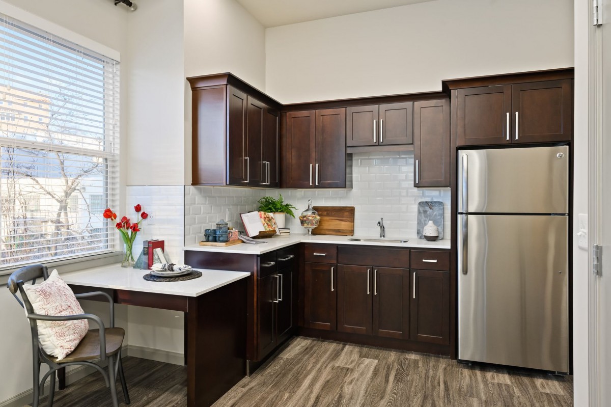 A modern kitchen featuring dark wood cabinets and stainless steel appliances.