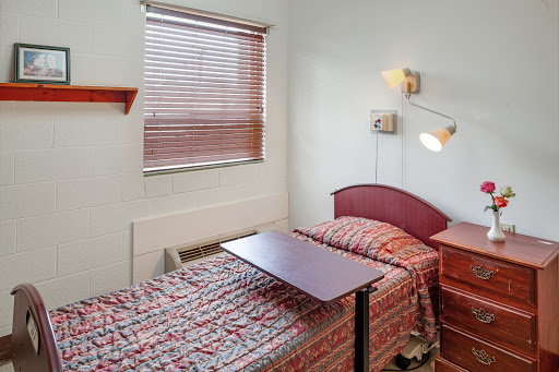 A cozy bedroom featuring two beds with patterned bedding and a small table.