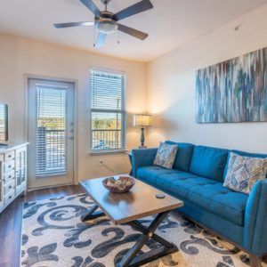 A cozy living room with a blue sofa, coffee table, and modern decor.