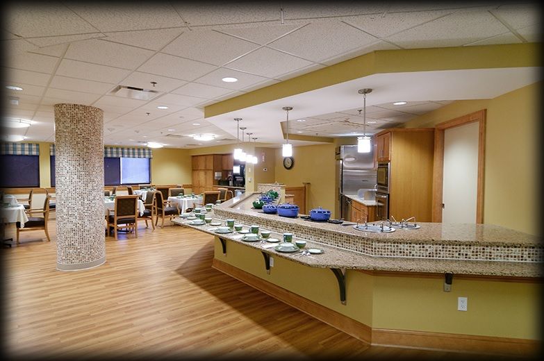 A spacious and modern kitchen area with a curved countertop and seating arrangement.
