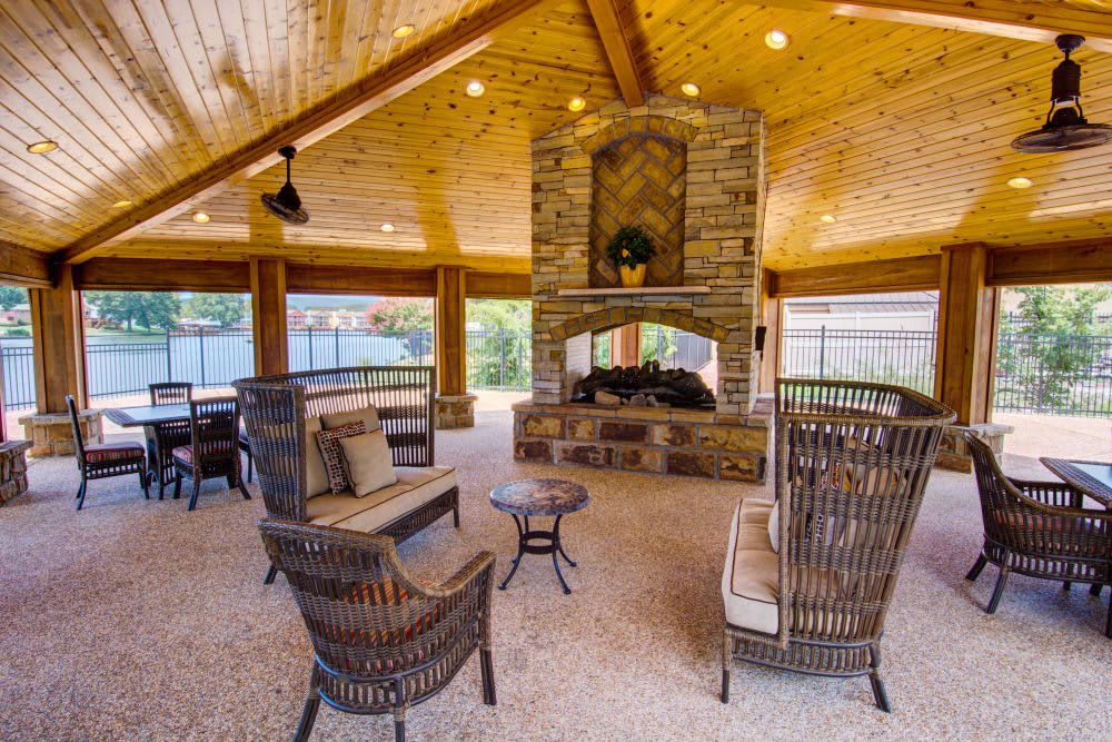 Spacious outdoor patio with a cozy seating area and stone fireplace.
