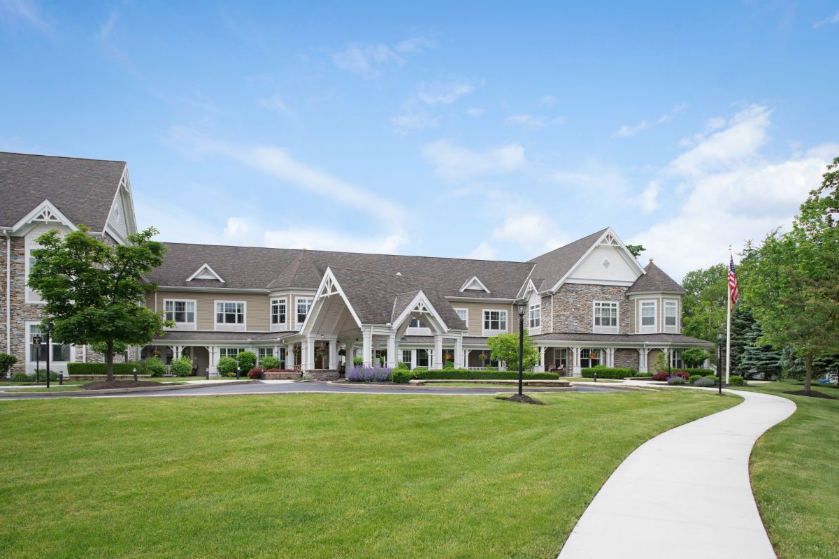 A large residential building with manicured lawns and clear blue sky.