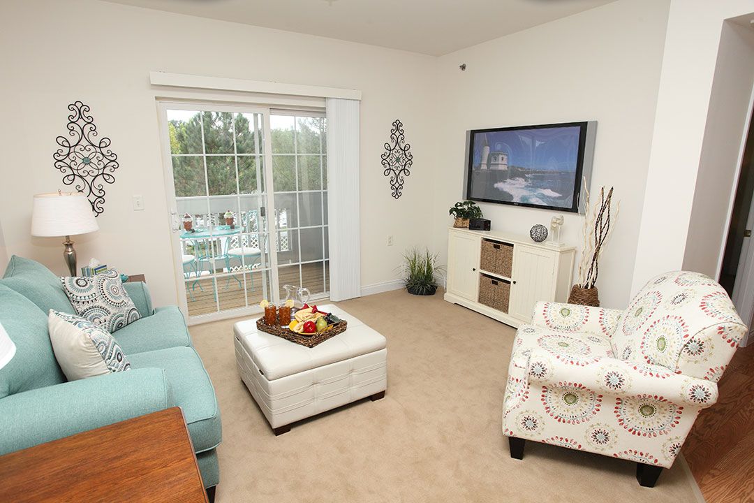 A cozy living room with modern decor and a sliding door leading to the balcony.