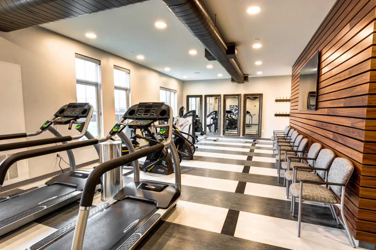 A modern gym equipped with treadmills and exercise machines, featuring a stylish interior design.