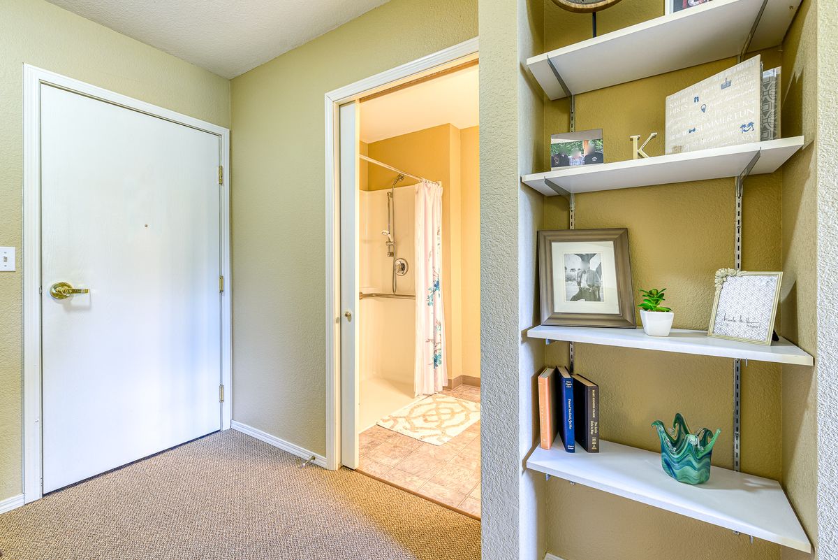 A cozy room with a bookshelf and an open door leading to another area.
