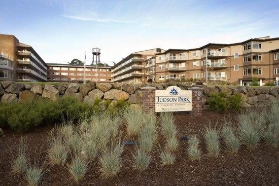 A view of a large residential building with a sign reading 'Linden Park Retirement Residence' amidst landscaped grounds.