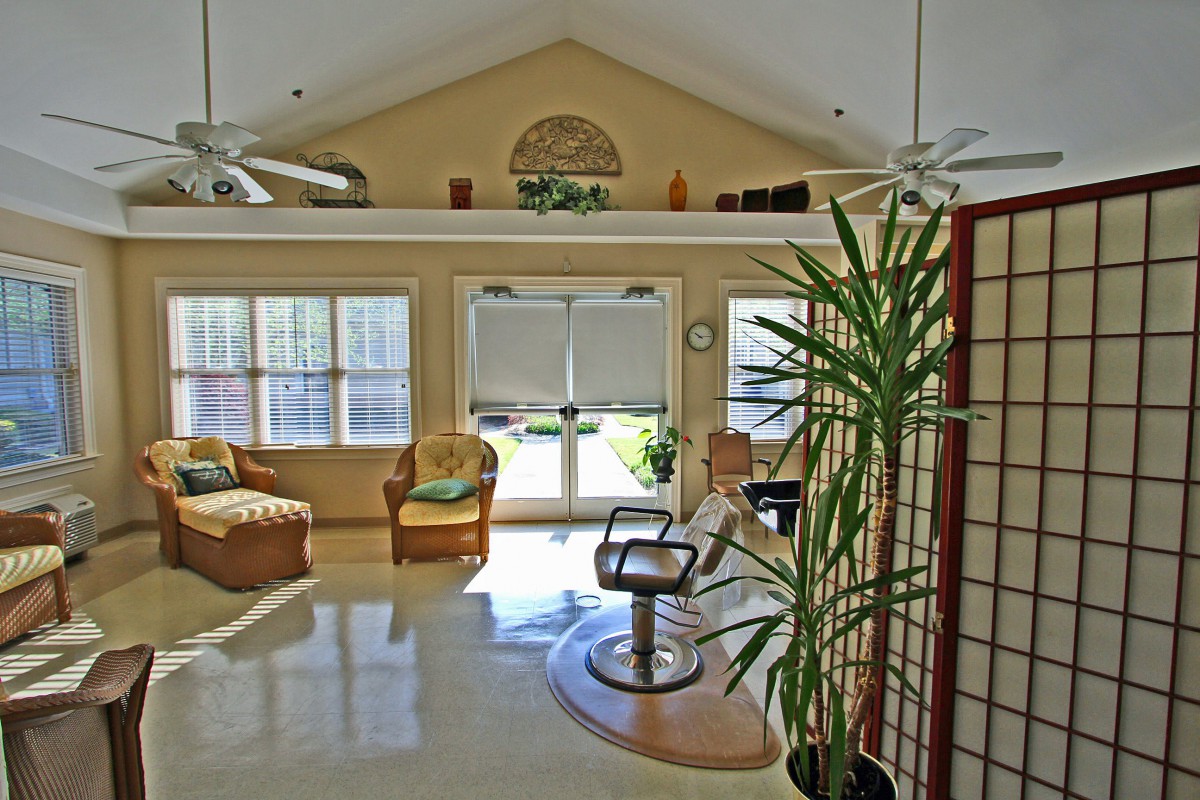A bright and airy salon interior with comfortable seating and large windows.