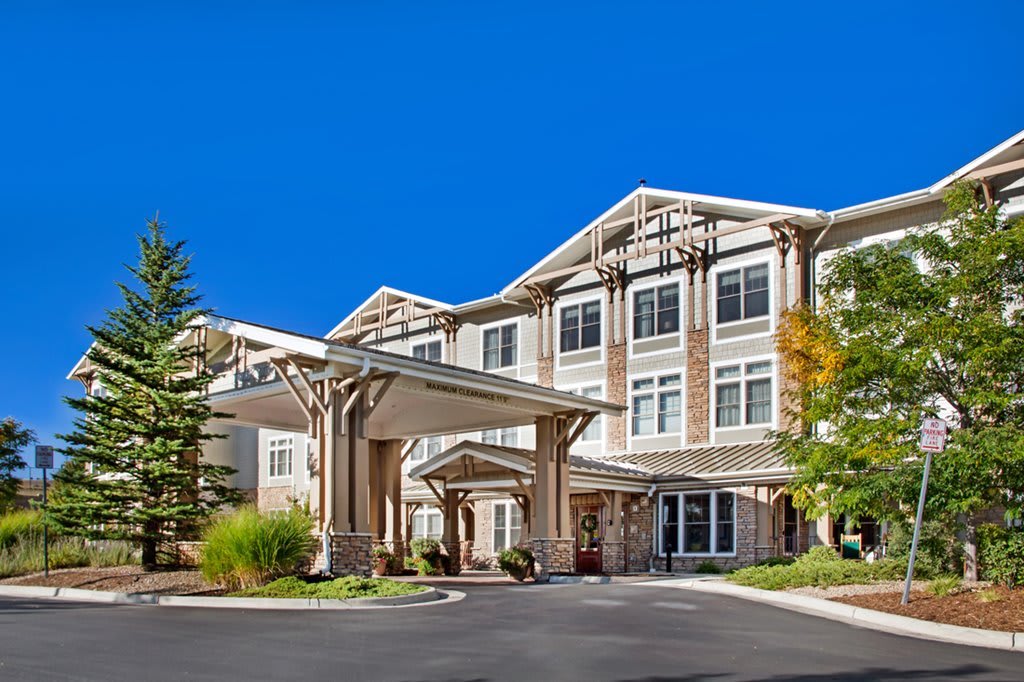 A modern residential building with a covered entrance on a sunny day.
