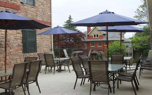 A cozy outdoor patio area with tables, chairs, and umbrellas, perfect for dining al fresco.