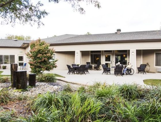 A view of a building with an outdoor patio area, surrounded by greenery.