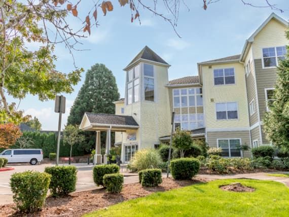 A residential building with well-maintained landscaping and a clear blue sky overhead.