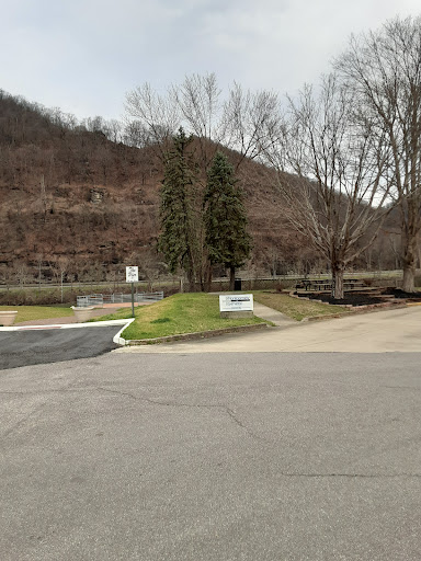 A view of a park entrance surrounded by trees and mountains.