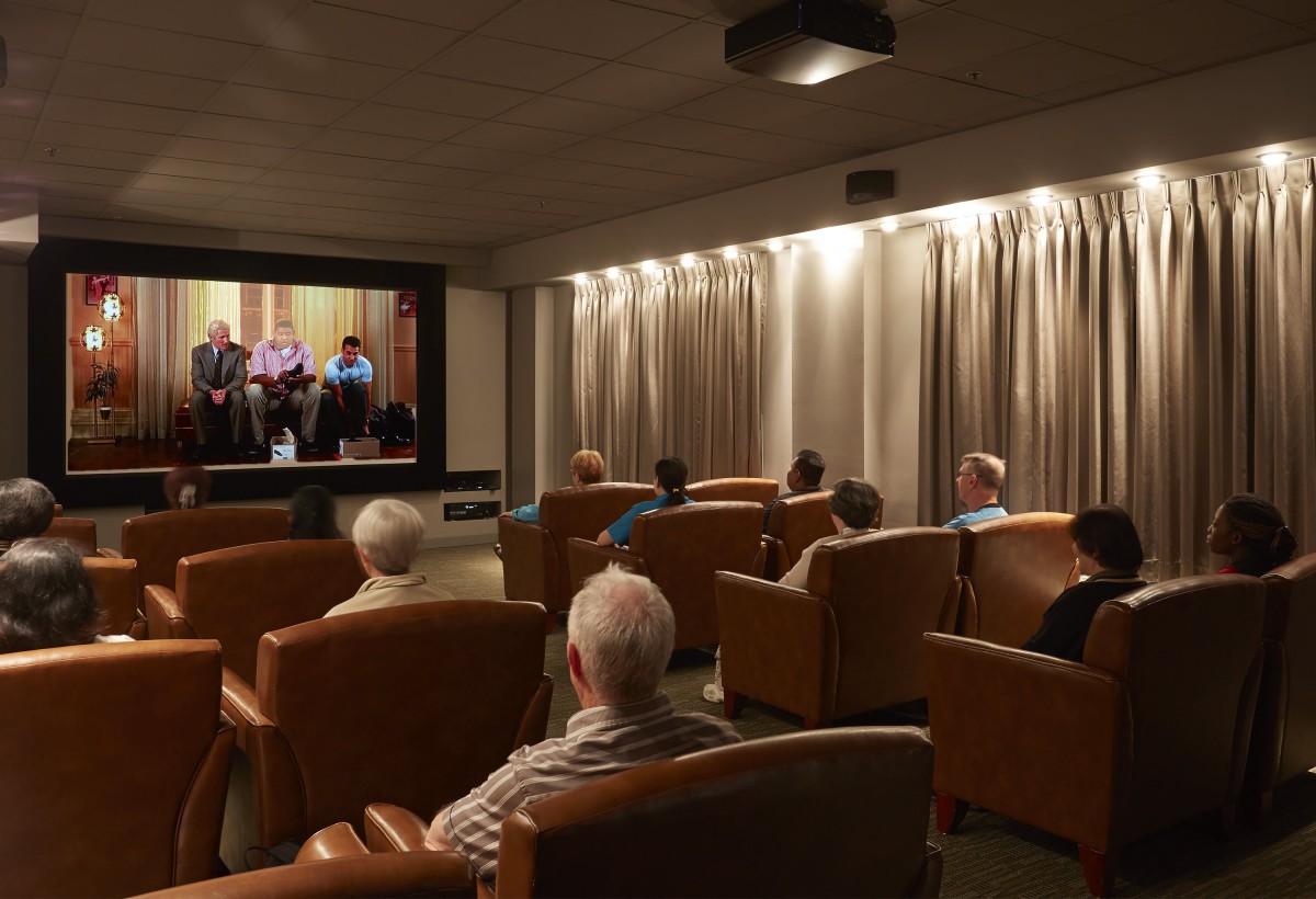 A group of people watching a movie in a cozy cinema room.