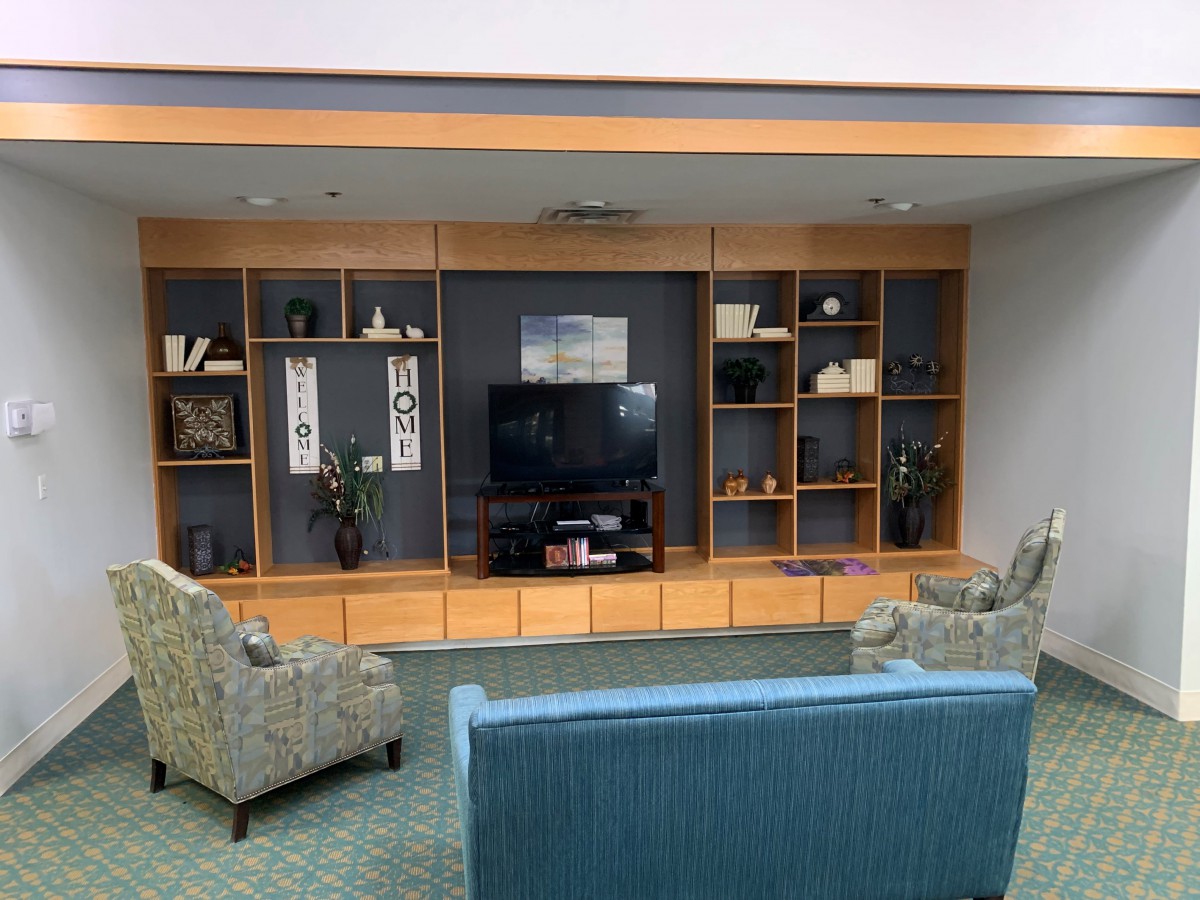A cozy living room setup with a television and decorative shelving.