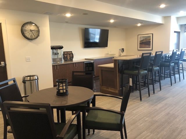 A modern indoor bar area with seating and a television.