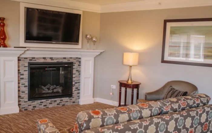 A cozy living room featuring a fireplace, wall-mounted television, and stylish furniture.
