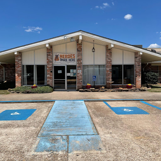 A storefront with handicap accessible parking in a clear blue sky.