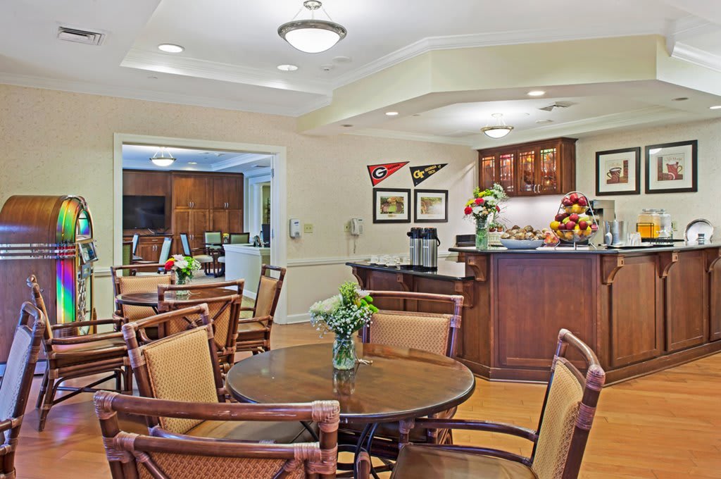 A cozy dining area with wooden furniture and a small kitchen space.