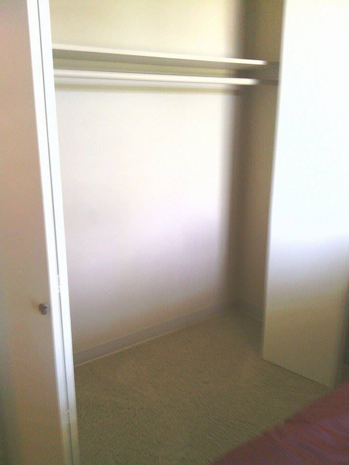 An empty closet interior with sliding doors.