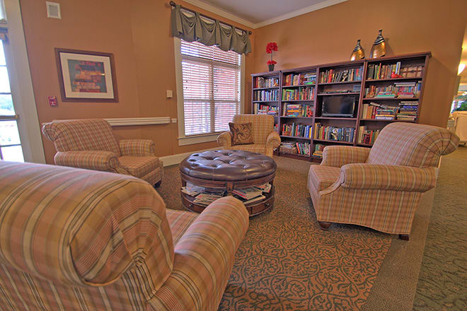 A cozy library with armchairs and bookshelves creating a warm, inviting atmosphere.