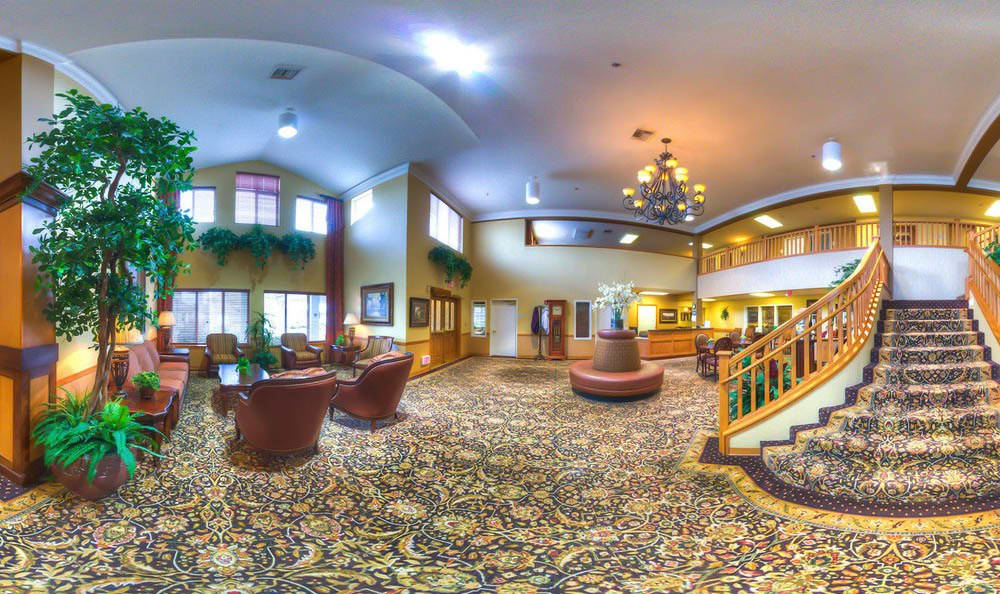 A spacious and elegantly decorated hotel lobby with comfortable seating, a chandelier, and a welcoming reception area.