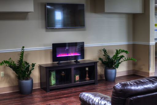 A cozy living room setup featuring a wall-mounted television and a stylish TV stand with an electric fireplace.