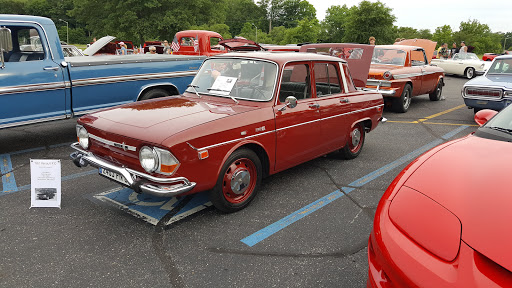 A beautifully restored vintage red car on display at a classic car show.