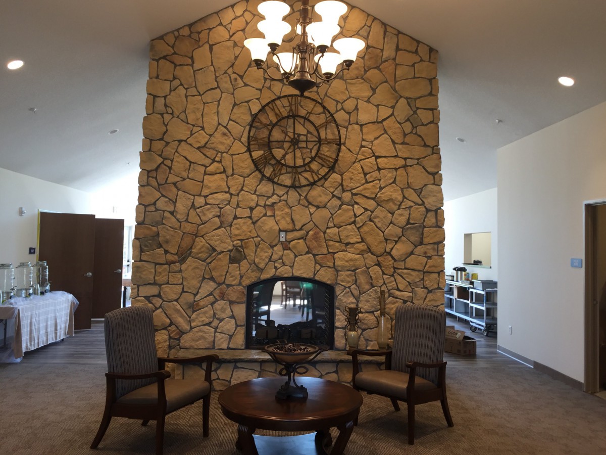 A cozy living room with a stone fireplace and elegant seating arrangement.