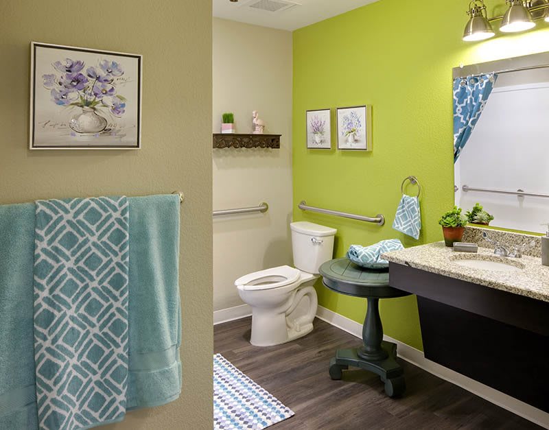 A modern bathroom with vibrant green walls and stylish decor.