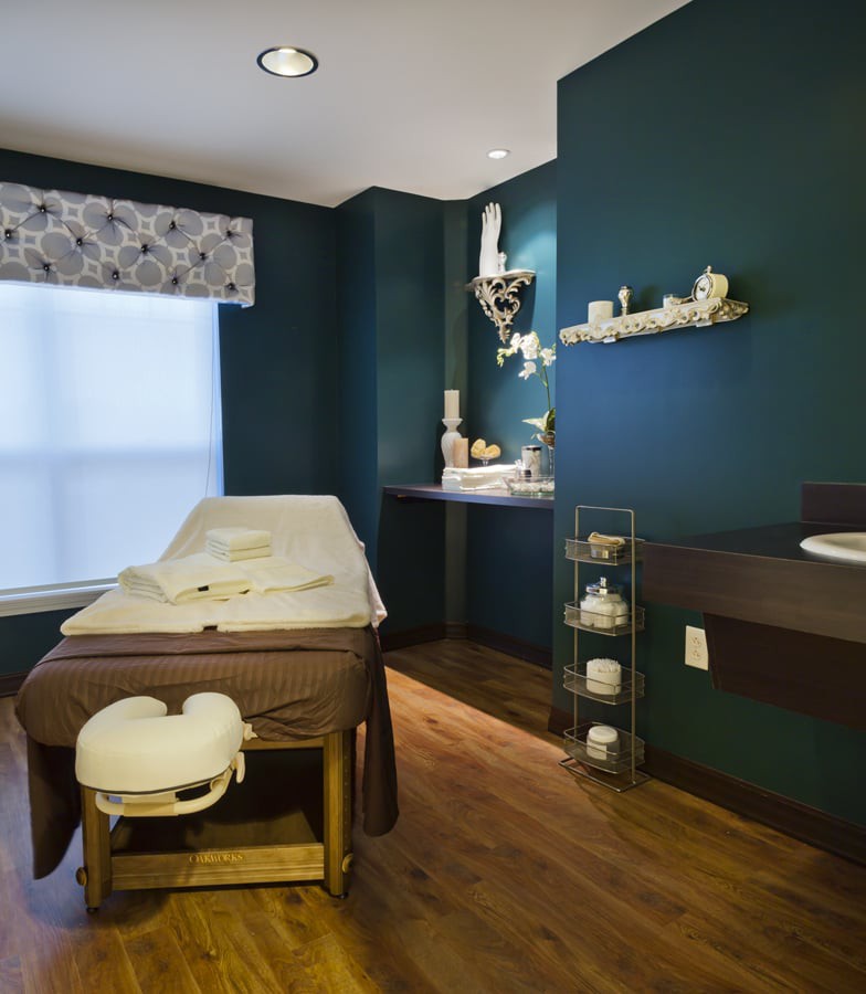 A serene massage room with a comfortable treatment table and calming decor.