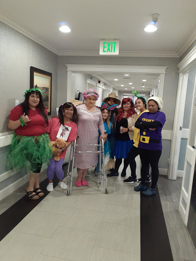 A lively group dressed in fun costumes, gathered in a hallway for a themed celebration.