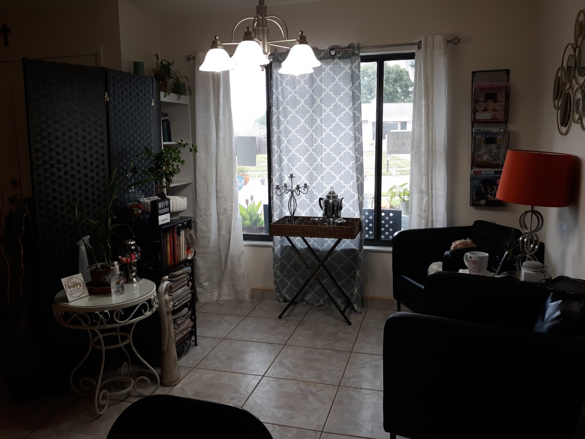 Cozy living room with a window view, plants, and comfortable seating.