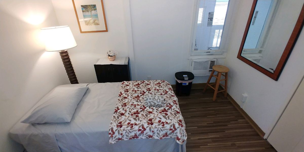 A cozy massage room with a therapy table covered in a floral blanket.