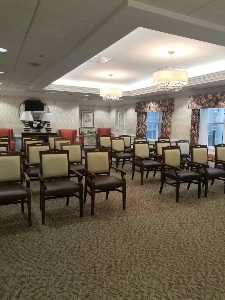 An empty meeting room with neatly arranged chairs facing the front.