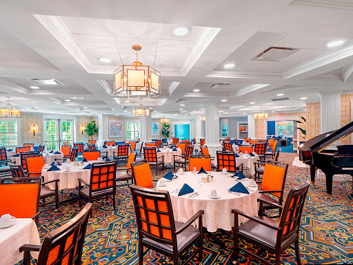 A beautifully arranged dining room featuring elegant tables and colorful chairs, perfect for a fine dining experience.
