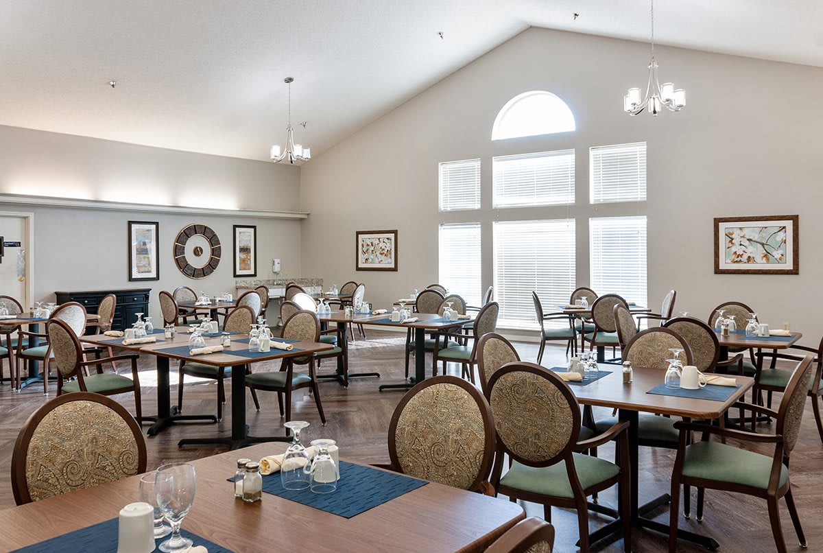 A well-lit dining area with neatly arranged tables and chairs.