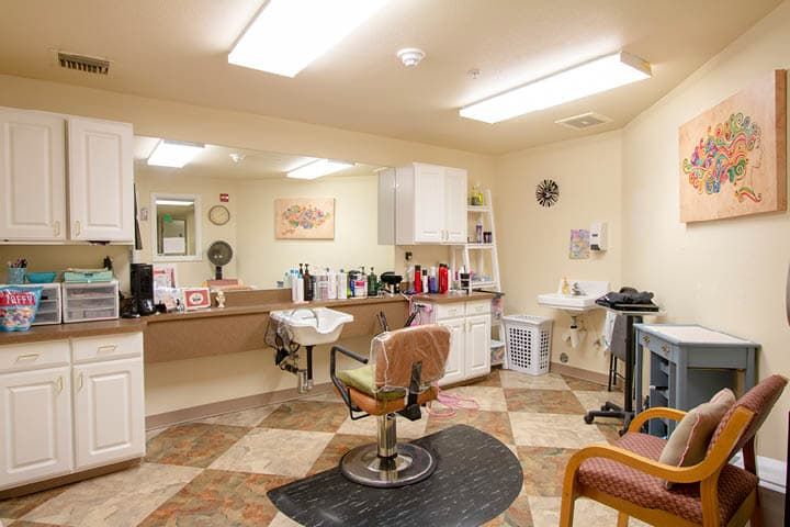A cozy hair salon with a styling chair, mirrors, and various hair products.