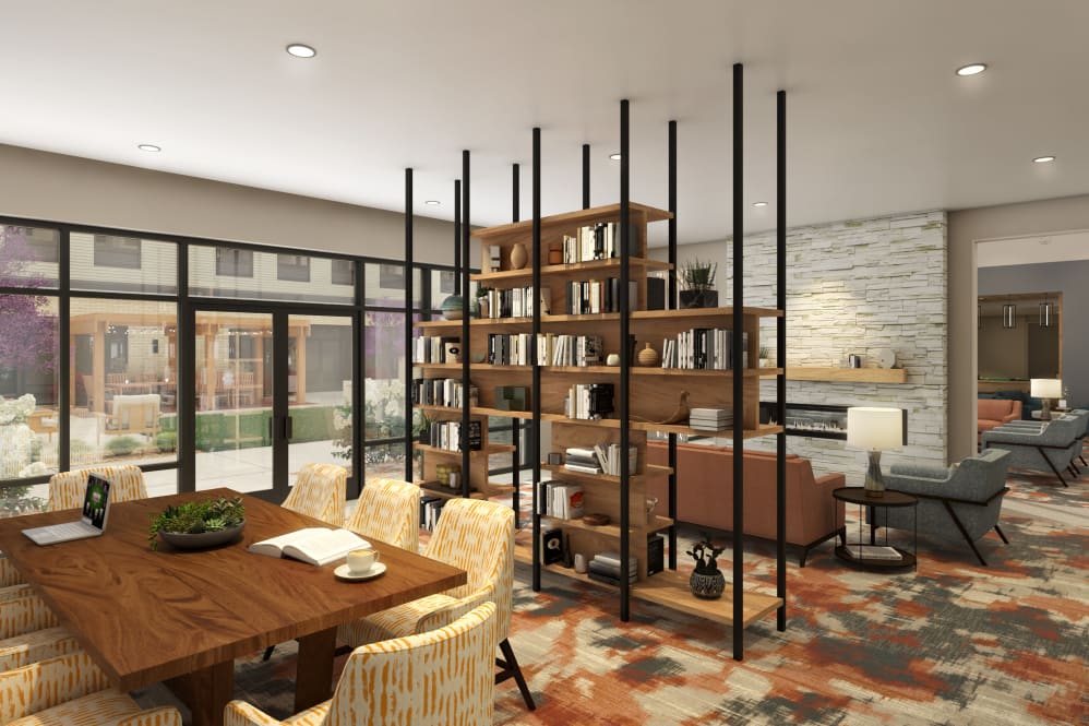 A modern open-space interior featuring a stylish living room and dining area with a central bookshelf divider.