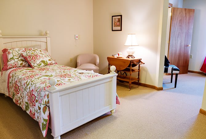 A cozy bedroom with a floral bedspread and warm lighting.