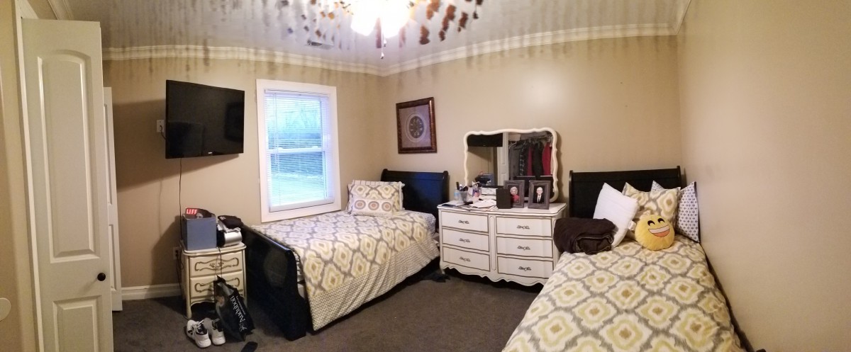 A cozy bedroom with twin beds and a dresser with a mirror.