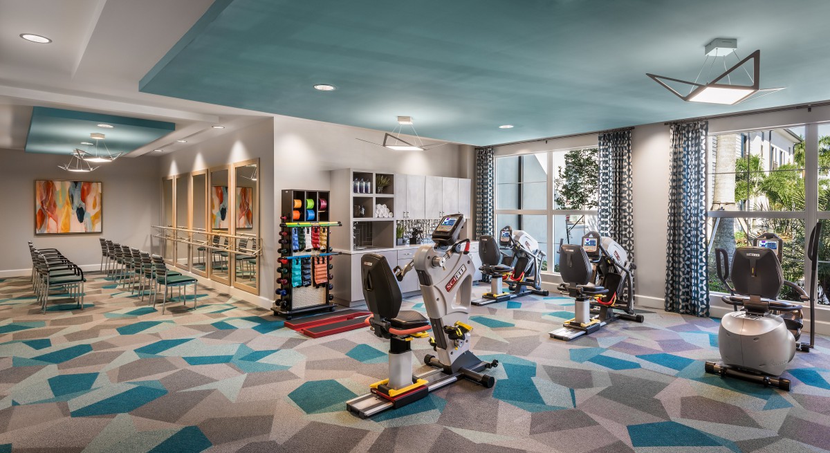 A modern gym with exercise equipment and bright, colorful decor.