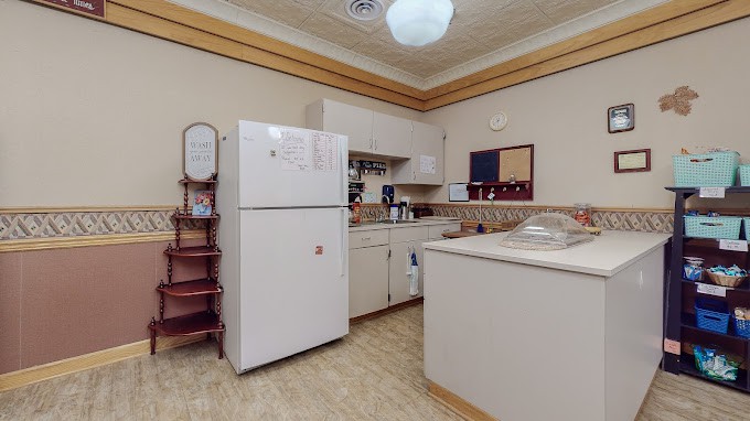 A cozy kitchen with a refrigerator, countertop, and cabinets.