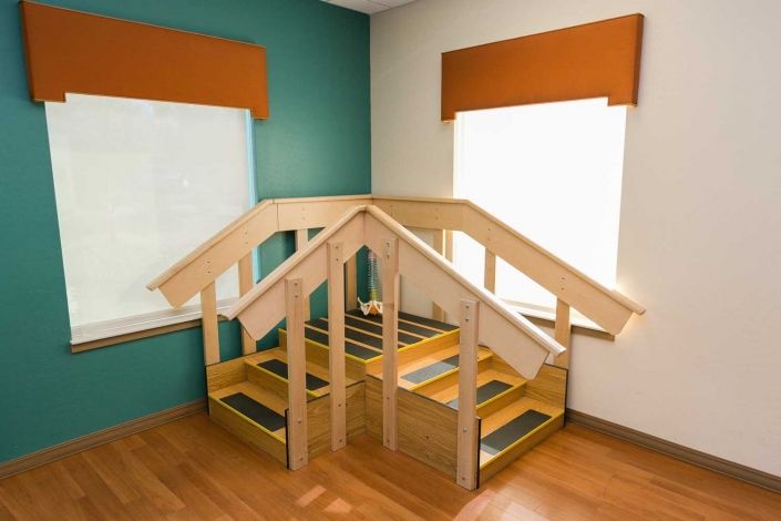 Wooden indoor play structure featuring stairs, designed for children.