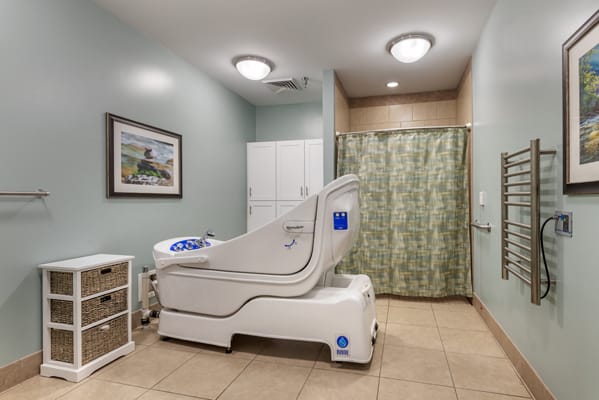 A healthcare facility room featuring an accessible bathtub designed for patient care.