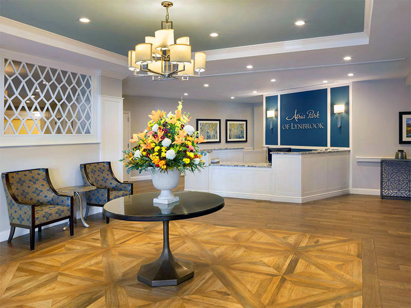 A stylish hotel lobby with a table centerpiece of flowers and elegant decor.