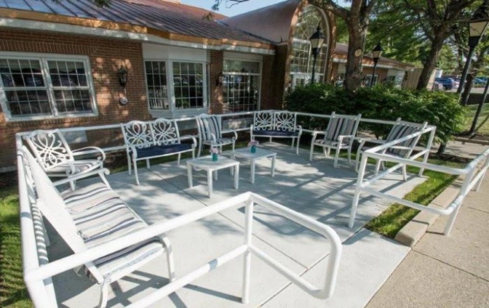 A cozy outdoor patio with metal furniture arranged in a circle, perfect for gatherings.