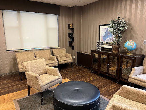 A cozy waiting room featuring modern furnishings and a warm color palette.
